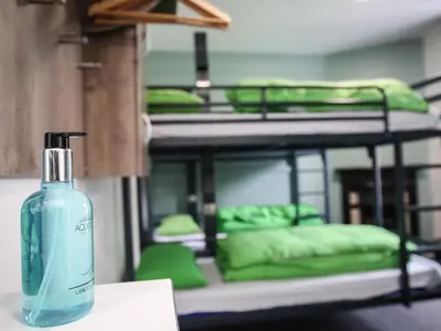 a bottle of soap sitting on a table in front of bunk beds at YHA Keswick in Keswick