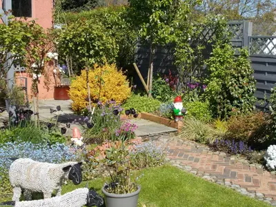 a garden with a sheep statue in the middle of it at Swiss Court Guest House in Keswick