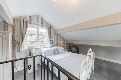 a bedroom with a bed and a balcony with a window at Jacksons CafeBar & Guesthouse in Grasmere