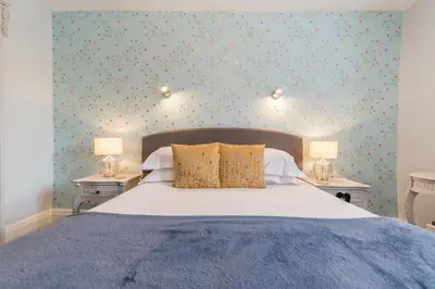 a bedroom with a bed and two tables with lamps at Jacksons CafeBar & Guesthouse in Grasmere
