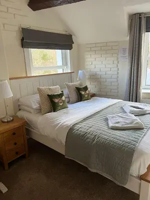 a bedroom with a large white bed with pillows at Babbling Brook Guesthouse in Keswick