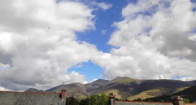 a cloudy sky with mountains in the background at Dolly Waggon Guest House in Keswick