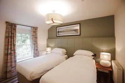 a bedroom with two beds and a window at Royal Oak Hotel in Rosthwaite