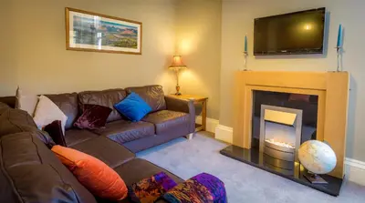 a living room with a couch and a fireplace at The Garden Apartment in Keswick