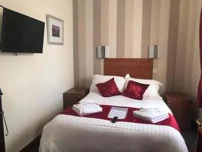 a bedroom with a bed with two pillows and a tv at The Globe Inn in Gosforth