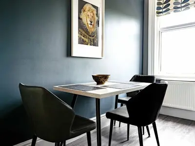 a dining room with a table and four chairs at Amadeus Apartments in Douglas