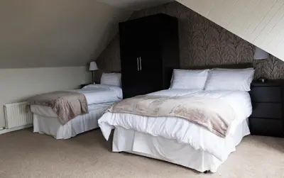 a bedroom with two beds with white sheets and a headboard at Harbourlights Accomodation in Irvine