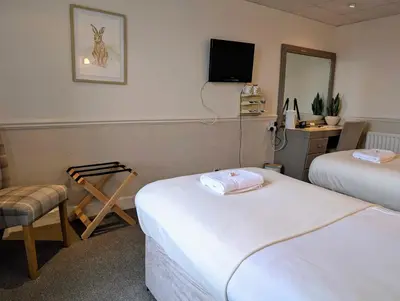 a hotel room with two beds and a mirror at Graham Arms Inn in Longtown