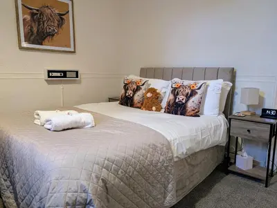 a bedroom with a bed with a teddy bear on it at Graham Arms Inn in Longtown