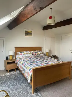 a bedroom with a large bed with a wooden frame at Rivendell Cottage in Douglas