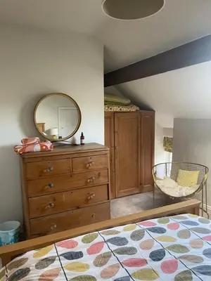 a bedroom with a dresser and a mirror at Rivendell Cottage in Douglas