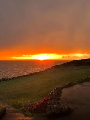 a sunset over the ocean with the sun setting at The Portpatrick Hotel by Compass Hospitality in Portpatrick