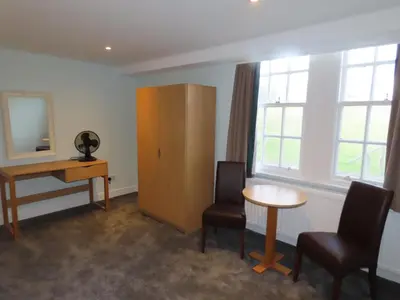 a room with a desk and two chairs and a table at The Portpatrick Hotel by Compass Hospitality in Portpatrick