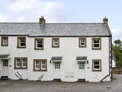 a large white house with white doors and windows at William Court Cottage in Santon Bridge