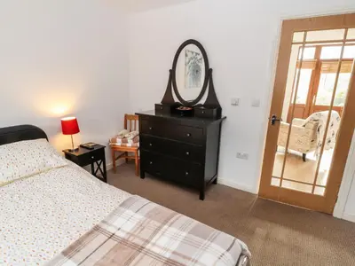 a bedroom with a bed and a mirror on a dresser at Nuthatch in Ivegill