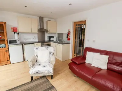 a living room with a couch and a red leather couch at Nuthatch in Ivegill