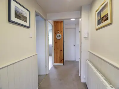 a hallway with a door and a clock on the wall at Kouloura in Mainsriddle