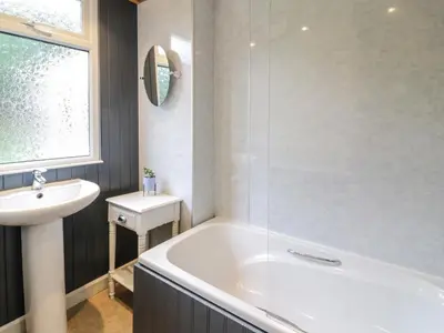 a bathroom with a white tub and a sink at Kouloura in Mainsriddle