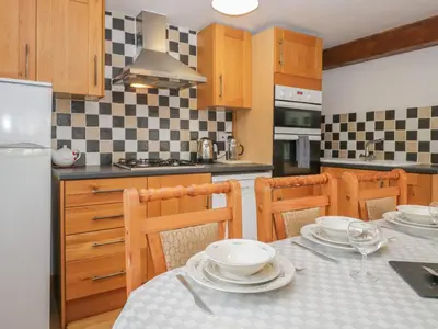 a kitchen with a table with plates on it at Bleng Barn Cottage in Seascale
