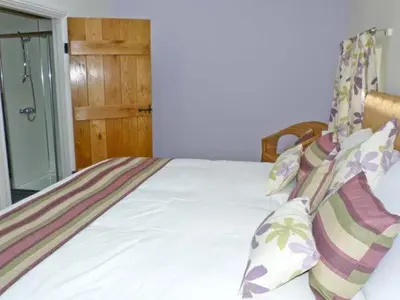 a bedroom with a bed with white sheets and pillows at Chimney Gill in Sebergham