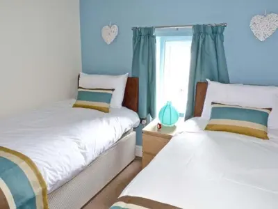 two beds in a bedroom with blue walls at Chimney Gill in Sebergham
