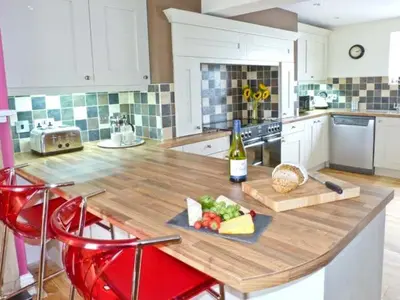 a kitchen with a wooden counter top with a bottle of wine at Chimney Gill in Sebergham