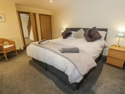 a bedroom with a large bed with pillows on it at The Old Brewery Store in Gatehouse of Fleet