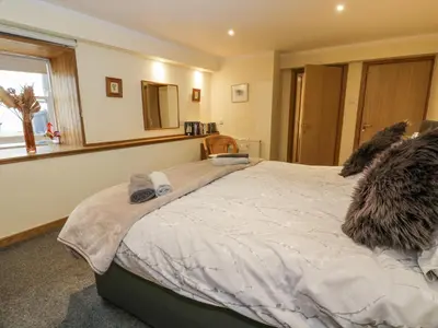 a bedroom with a large bed in a room at The Old Brewery Store in Gatehouse of Fleet