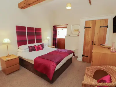 a bedroom with a bed and a chair in it at The Old Grainstore in Wigton