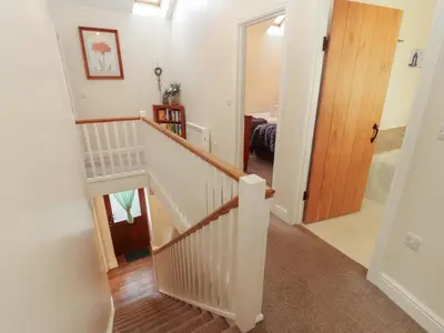 a hallway with a staircase leading to a bedroom at The Old Grainstore in Wigton