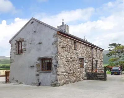 an old stone building with a cross on top of it at Fell View Cottage in Bootle