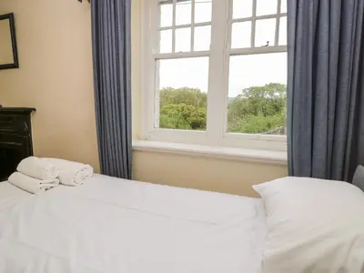 a bedroom with two white beds and a window at Peel Place Noddle in Eskdale