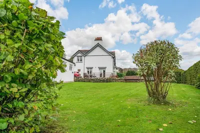 a white house with a bench in a yard at Peel Place Noddle in Eskdale