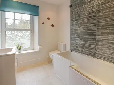a bathroom with a tub and a toilet and a window at 79 Laurel Bank in Gatehouse of Fleet