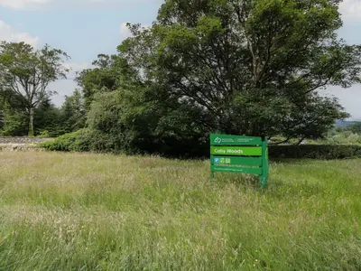 a green sign in the middle of a field at 79 Laurel Bank in Gatehouse of Fleet