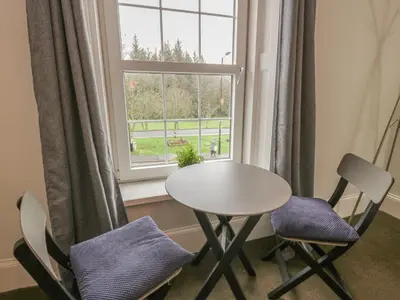 a table and two chairs in front of a window at 79 Laurel Bank in Gatehouse of Fleet