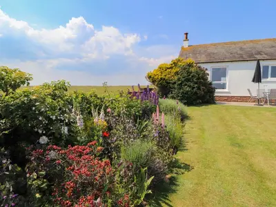 a garden in front of a house with flowers at West Croft in Mawbray