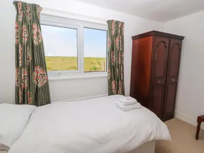 a bedroom with a bed and a window at West Croft in Mawbray
