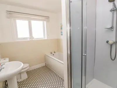 a bathroom with a shower and a toilet and a sink at West Croft in Mawbray