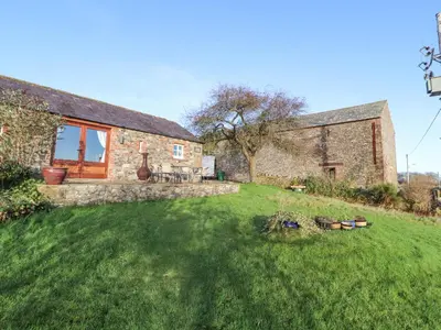 an external view of a stone house with a yard at Sonya's Cottage in Anthorn