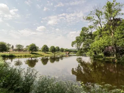 a view of a river with trees and clouds in the sky at The Mews Flat in Dalswinton