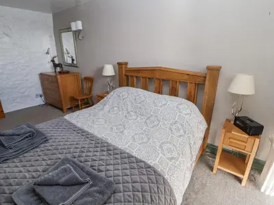 a bedroom with a bed with a gray comforter at Mellfell Cottage in Watermillock