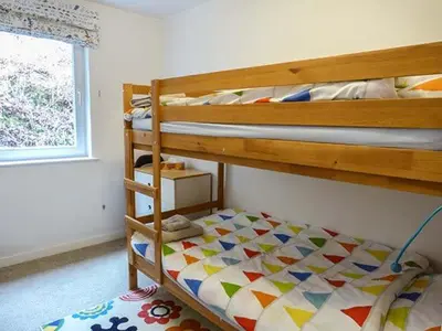 a bedroom with two bunk beds and a window at Fish House in Kirkcudbright
