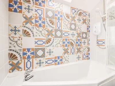 a bathroom with blue and white tiles on the wall at Simmer Dim in Kirkbean