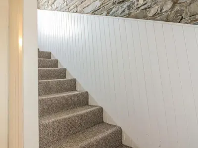 a staircase in a house with a stone wall at The Pink House in Isle of Whithorn