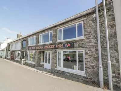 a brick building with a sign that reads the sixth brick inn at The Pink House in Isle of Whithorn
