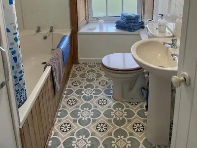 a bathroom with a toilet and a sink and a tub at The Pink House in Isle of Whithorn