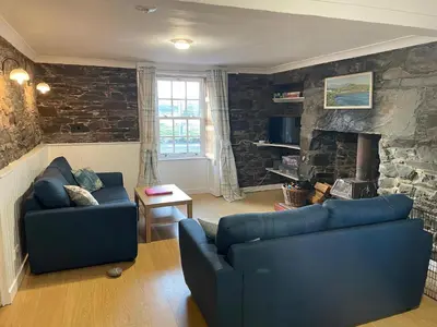 a living room with two blue couches and a fireplace at The Pink House in Isle of Whithorn