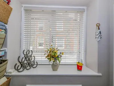 a window with a vase of flowers on a window sill at Nathaniel's Cottage in Kirkcudbright