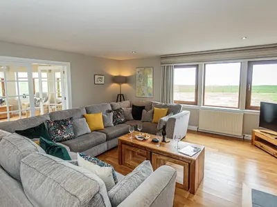 a living room with a couch and a tv at Corsewall Castle Farm Lodges in Kirkcolm